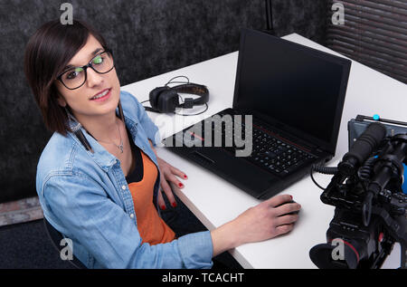 Jolie jeune femme éditeur vidéo travaillant en studio Banque D'Images