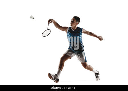 Petit garçon jouer au badminton isolated on white background studio. Jeune modèle masculin en sportwear et chaussures avec la raquette en action, mouvement dans le jeu. Concept de mouvement, sport, mode de vie sain. Banque D'Images