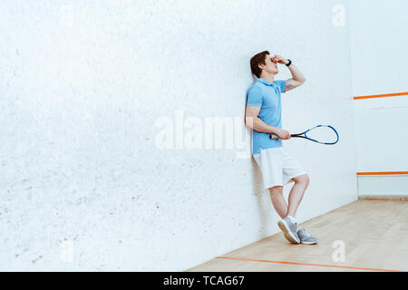Sur toute la longueur du joueur de squash fatigué de se toucher les yeux avec la main Banque D'Images