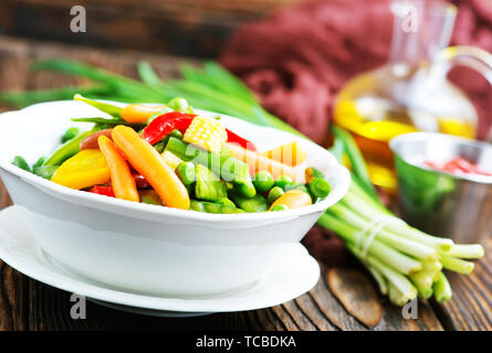 Mélanger les légumes dans le bol et sur une table Banque D'Images