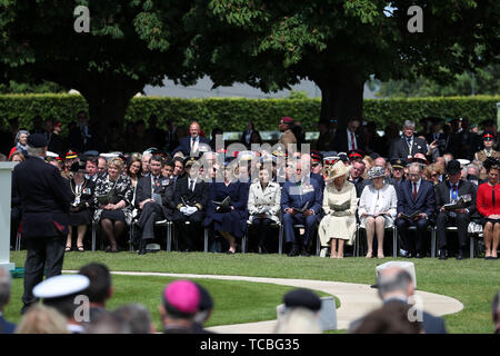 Le Prince de Galles et la duchesse de Cornouailles écouter Frank vétéran Baugh (à gauche), qui a servi comme un signaleur avec la Royal Navy sur un débarquement LORS D-Day au cours de la Royal British Legion's Service du souvenir, à la Commonwealth War Graves Commission Cemetery, à Bayeux, France, dans le cadre de commémorations pour le 75e anniversaire du débarquement. Banque D'Images