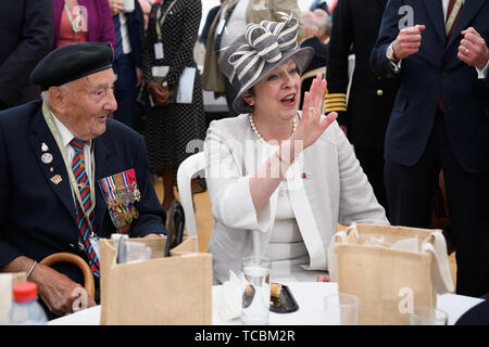 Premier ministre Theresa peut courbes à un autre homme alors qu'elle discute avec Leslie vétéran suite à l'ensemencement de service du Royal British Legion du Souvenir, à la Commonwealth War Graves Commission Cemetery, à Bayeux, France, dans le cadre de commémorations pour le 75e anniversaire du débarquement. Banque D'Images