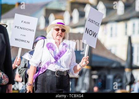 Pays de Galles Aberystwyth UK, jeudi 06 juin 2019 un groupe de porteurs de pancartes grannies dans leur 60s, habillés comme des suffragettes, marchant le long de la promenade à Aberystwyth dans le cadre d'une protestation contre l'augmentation de l'âge de la retraite pour les femmes . WASPI [les femmes contre l'injustice de l'Etat] font campagne pour renverser la décision de changer l'âge de la pension à 67 ans pour les femmes nées dans les années 1950 . Il y a 5 000 femmes dans Ceredigion né dans les années 50 qui ont perdu des années de leur pension en raison de l'accélération du gouvernement politique. La légalité de ces changements est aujourd'hui à l'essai Banque D'Images