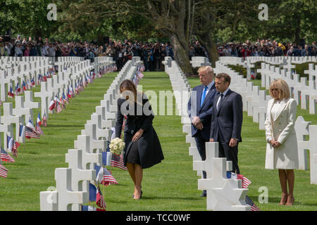 Première Dame des États-Unis Melania Trump met des fleurs sur la tombe d'un membre du service américain enterré au cimetière américain de Normandie en tant que président, Donald Trump/ Président français Emmanuel Macron et sa femme Brigitte Macron rechercher dans le cours d'une cérémonie marquant le 75e anniversaire du Jour J à la cimetière américain de Normandie le 6 juin 2019 à Colleville-sur-Mer, France. Des milliers de personnes ont convergé sur Normandie pour commémorer le 75e anniversaire de l'opération Overlord, l'invasion alliée DE LA SECONDE GUERRE MONDIALE connue sous le nom de D-Day. Banque D'Images