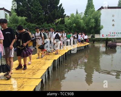 Nanchang. 7 juin, 2019. Tenue de l'examen d'entrée au collège national de marche sur un pont d'accès de fortune pour entrer dans la salle d'examen au n° 1 Middle School de Yushan County de Ganzhou, Chine de l'est la province de Jiangxi, du 7 juin 2019. Le premier jour de l'entrée au collège national de la Chine, d'examen ou un pont d'accès, Gaokao faites par un bureau a été construit pour les étudiants d'obtenir à travers la zone inondée au lieu d'un examen dans Yushan. Yushan a été touché par de fortes pluies diluviennes jeudi. Le Gaokao a commencé vendredi dernier. Source : Xinhua/Alamy Live News Banque D'Images