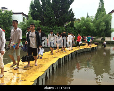 Nanchang. 7 juin, 2019. Tenue de l'examen d'entrée au collège national de marche sur un pont d'accès de fortune pour entrer dans la salle d'examen au n° 1 Middle School de Yushan County de Ganzhou, Chine de l'est la province de Jiangxi, du 7 juin 2019. Le premier jour de l'entrée au collège national de la Chine, d'examen ou un pont d'accès, Gaokao faites par un bureau a été construit pour les étudiants d'obtenir à travers la zone inondée au lieu d'un examen dans Yushan. Yushan a été touché par de fortes pluies diluviennes jeudi. Le Gaokao a commencé vendredi dernier. Source : Xinhua/Alamy Live News Banque D'Images