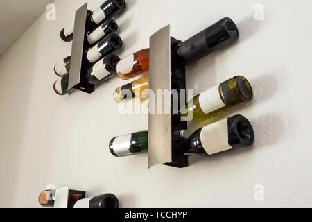 Les bouteilles de vin en rack moderne sur mur blanc dans le salon retro Banque D'Images
