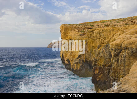 Falaises où Fenêtre d'Azur se sont effondrés éclairées par la lumière au coucher du soleil sur la côte de l'île de Gozo, Malte. Banque D'Images