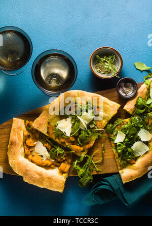 Pizza blanche traditionnelle Italienne avec fromage pecorino et taleggio, caramélisée et potiron roquette sur le tableau bleu Banque D'Images