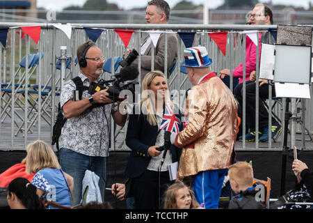 Un journaliste et homme de l'appareil photo d'une entrevue avec un homme vêtu de vêtements union jack à une commémoration Banque D'Images