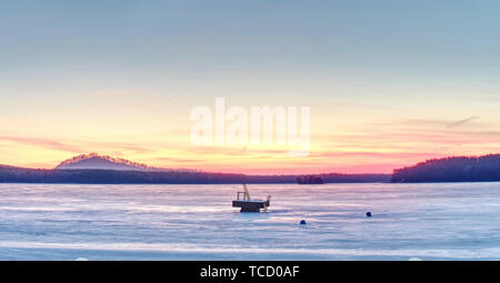 Summer resort sous la glace à l'intérieur de long hiver. Coucher de soleil à couper le souffle d'or et rose avec des nuages sur lac gelé Banque D'Images