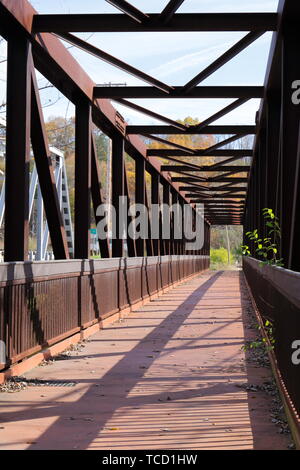 Vue en perspective à la recherche sur le chemin d'un chemin piétonnier à travers un pont en treillis Banque D'Images