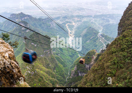 Chemin de câble panier dans le motion blur, les câbles et les charrettes de disparaître dans la profondeur de la vallée et la ville ci-dessous, la montagne Tianmen, Zhangjiajie, Hunan, Chine Banque D'Images