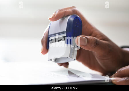 Close-up of Businesswoman Putting Stamp sur Documents dans le bureau Banque D'Images