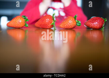 La main de bébé manipuler différents fruits sur une table en bois Banque D'Images