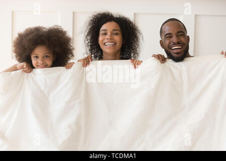 Happy african american family bonding rire holding couette blanche et chaude Banque D'Images