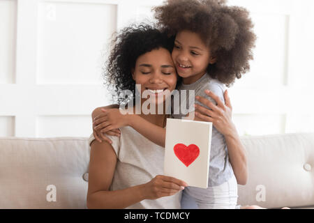 Maman africaine hugging daughter holding sur la fête des mères, carte de vœux Banque D'Images