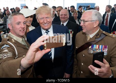 Président américain Donald Trump et la Première Dame Melania Trump posent avec les membres du service de service actif au cours d'une cérémonie marquant le 75e anniversaire du D-Day le 5 juin 2019, à Portsmouth, en Angleterre. Banque D'Images