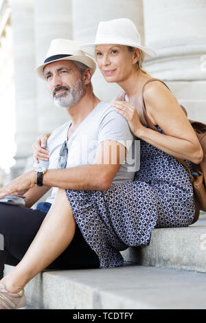 Young couple sitting on steps à l'extérieur Banque D'Images