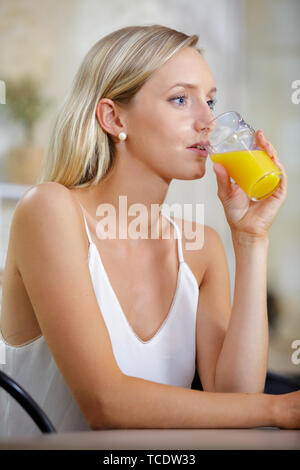 Jeune femme à boire le jus d'orange au bar restaurant Banque D'Images