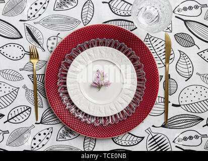 Ensemble de tables de fête avec plaque rouge et or table ware, avec nappe blanche sur verre Banque D'Images