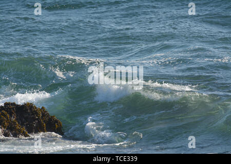 Vue de l'eau clair transparent formant l'enflure et la vague d'exécution sur rock in ocean Banque D'Images