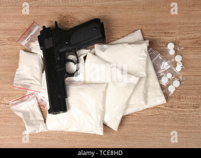La cocaïne et la marihuana en paquets avec pistolet sur fond de bois Banque D'Images