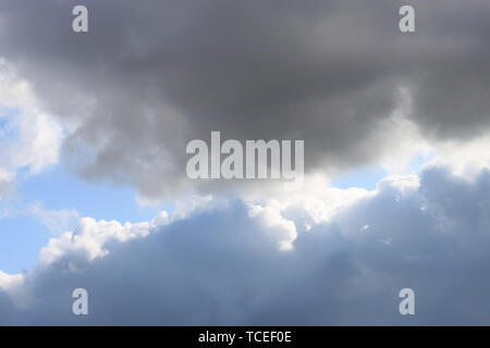 Des nuages gris dans le ciel bleu Banque D'Images