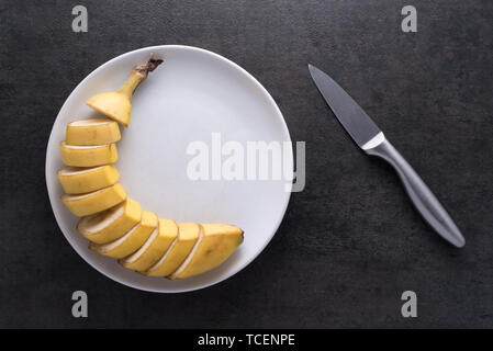 Scliced banana on white plate Banque D'Images