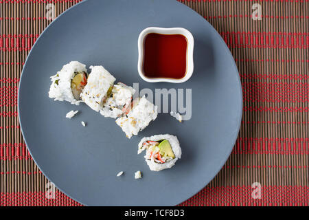 Au-dessus de close up of soy couché à côté de cut sushi Banque D'Images