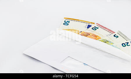 L'introduction des billets dans l'enveloppe blanche sur fond blanc, une notion, la corruption, copy space Banque D'Images