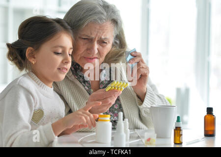Cute girl d'administrer un médicament à un senior woman Banque D'Images