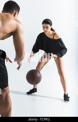 Attractive african american girl en noir de danseur à jouer au ballon avec mixed race man on white Banque D'Images