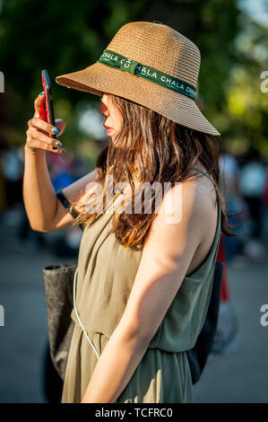 Une dame asiatique en vacances prend une photo touristique sur son téléphone portable à La Porte Pae, Chiang Mai, Thaïlande, Asie du Sud-est. Banque D'Images