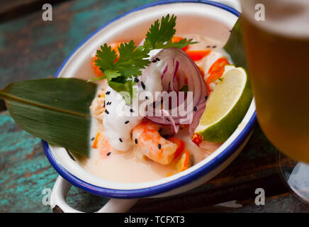 Délicieux ceviche de crevettes dans un style vietnamien servi sur des feuilles de bambou avec du lait de coco Banque D'Images