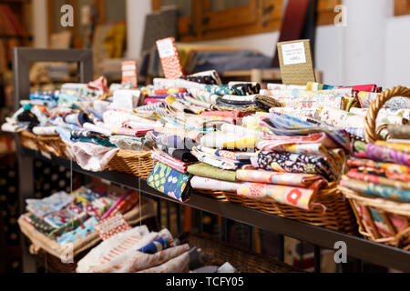 Avis de rouleaux de tissu de différentes couleurs et de motifs sur des étagères en tissu boutique Banque D'Images