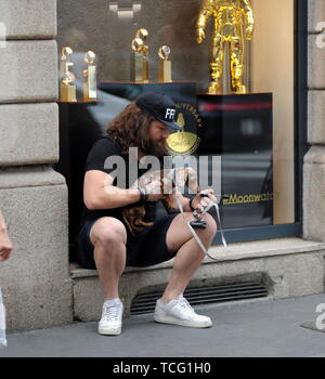 Milan, Italie. 07Th Juin, 2019. Martin Castrogiovanni avec son nouveau chien prend le taxi Martin Castrogiovanni-argentin, né italien, ancien joueur de rugby de l'équipe nationale italienne et maintenant un plat de personnalité, premier concurrent de 'Dancing with the stars' puis 'Tu sÃ¬ que vales', arrive en ville avec son petit chien le Tito et en attente de prendre un taxi, il est reconnu par beaucoup de gens qui font appel à lui pour des photos souvenirs, et même un mendiant lui parvient à obtenir quelques pièces. Credit : Agence Photo indépendant Srl/Alamy Live News Banque D'Images