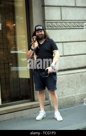 Milan, Martin Castrogiovanni avec son nouveau chien prend le taxi Martin Castrogiovanni-argentin, né italien, ancien joueur de rugby de l'équipe nationale italienne et maintenant un plat de personnalité, premier concurrent de 'Dancing with the stars' puis 'Tu sÃ¬ que vales', arrive en ville avec son petit chien le Tito et en attente de prendre un taxi, il est reconnu par beaucoup de gens qui font appel à lui pour des photos souvenirs, et même un mendiant lui parvient à obtenir quelques pièces. Banque D'Images