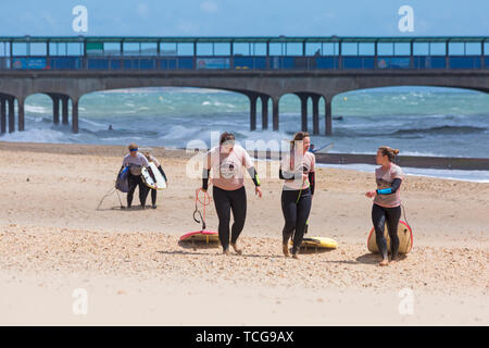 Bournemouth, Dorset, UK. 8 juin 2019. UK météo : vent, avec du soleil et des douches à plages de Bournemouth, comme quelques braves-hearted tête à la mer. Les surfeurs sur la plage de Boscombe. Credit : Carolyn Jenkins/Alamy Live News Banque D'Images