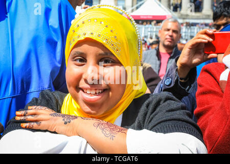 Trafalgar Square, Londres, Royaume-Uni, le 08 juin 2019. Une jeune fille aime regarder les performances. Les spectateurs sur la place. Des milliers de Londoniens et les visiteurs arrivent ensemble à Trafalgar Square pour célébrer la fin du Ramadan et Eid Festival, ainsi que la riche diversité culturelle de Londres. Le festival est organisé par le maire de Londres Sadiq Khan. Banque D'Images