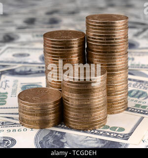 Pile de pièces de monnaie de l'Ukraine dans l'augmentation des stacks grandir. L'argent de l'Ukraine se trouve sur cent US dollar bills Banque D'Images