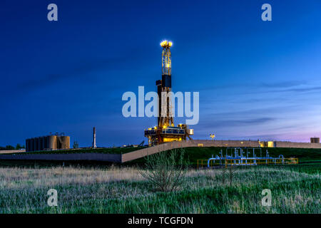 Une plate-forme de forage dans la nuit dans les champs de pétrole de Bakken jouer près de Williston, Dakota du Nord, USA. Banque D'Images