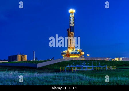 Une plate-forme de forage dans la nuit dans les champs de pétrole de Bakken jouer près de Williston, Dakota du Nord, USA. Banque D'Images