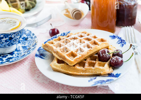 Set de table pour le petit-déjeuner avec différentes sortes de gaufres en bonne santé, de confitures et de fruits rouges Banque D'Images