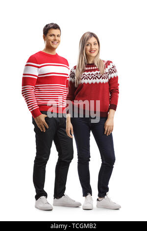 Portrait d'un jeune mâle et femelle portant des chandails rouge noël et posant isolé sur fond blanc Banque D'Images
