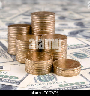 Pile de pièces de monnaie de l'Ukraine dans l'augmentation des stacks grandir. L'argent de l'Ukraine se trouve sur cent US dollar bills Banque D'Images