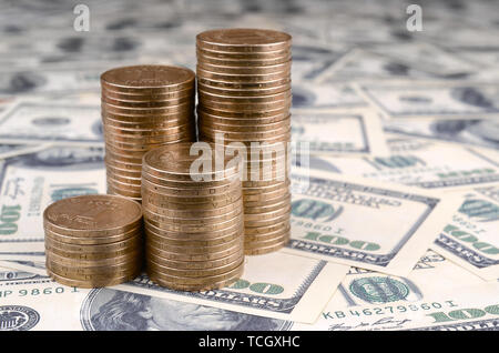 Pile de pièces de monnaie de l'Ukraine dans l'augmentation des stacks grandir. L'argent de l'Ukraine se trouve sur cent US dollar bills Banque D'Images
