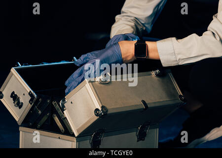 Portrait de l'enquêteur dans les gants en caoutchouc avec kit d'enquête au lieu de crime Banque D'Images
