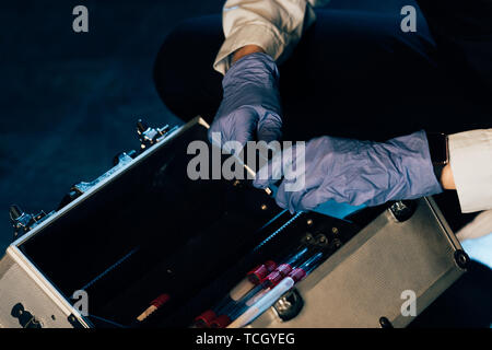 Portrait de l'enquêteur dans les gants en caoutchouc avec kit d'enquête au lieu de crime Banque D'Images