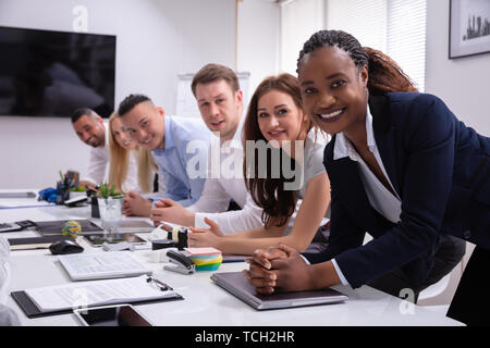 Groupe multiracial de Happy Woman Sitting in Row Looking at Camera Banque D'Images